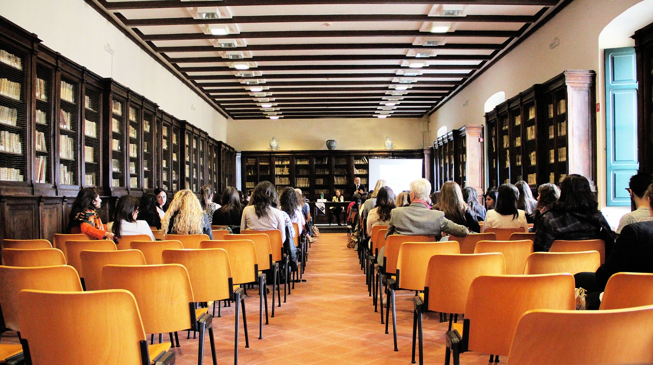 Rows of orange auditorium chairs in a historic library