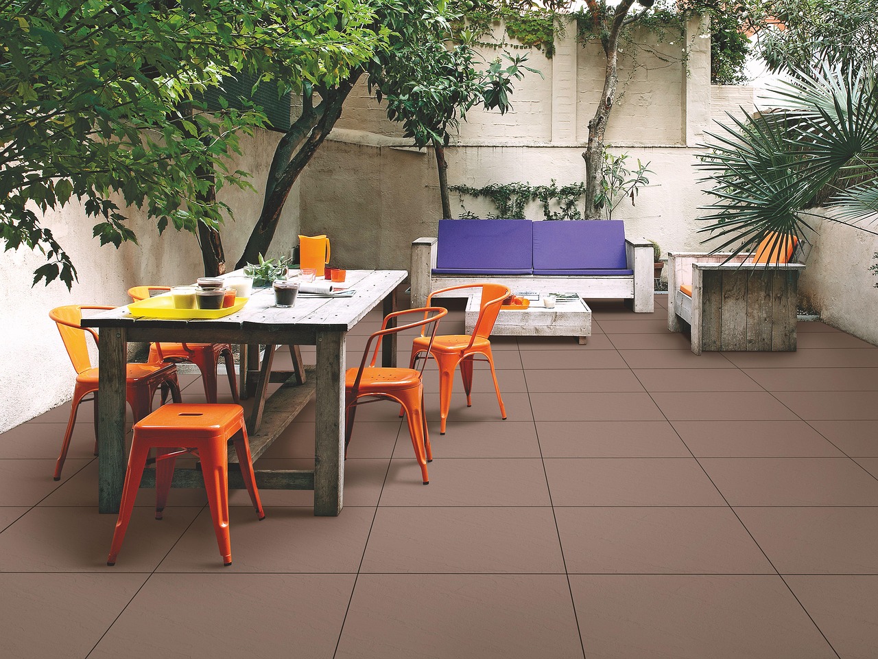 Orange metal café chairs around a rustic patio table