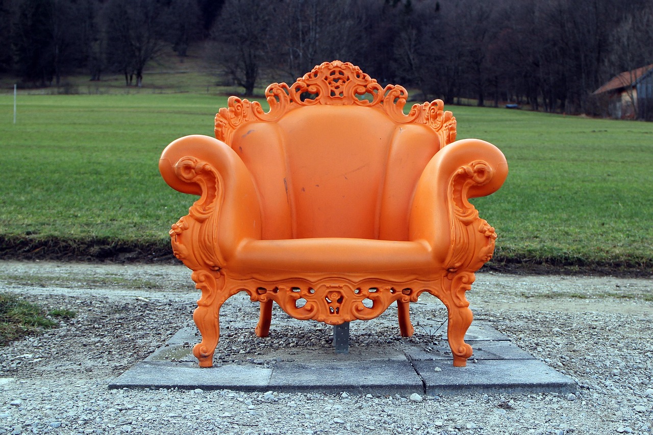 Ornate baroque orange armchair on a lawn